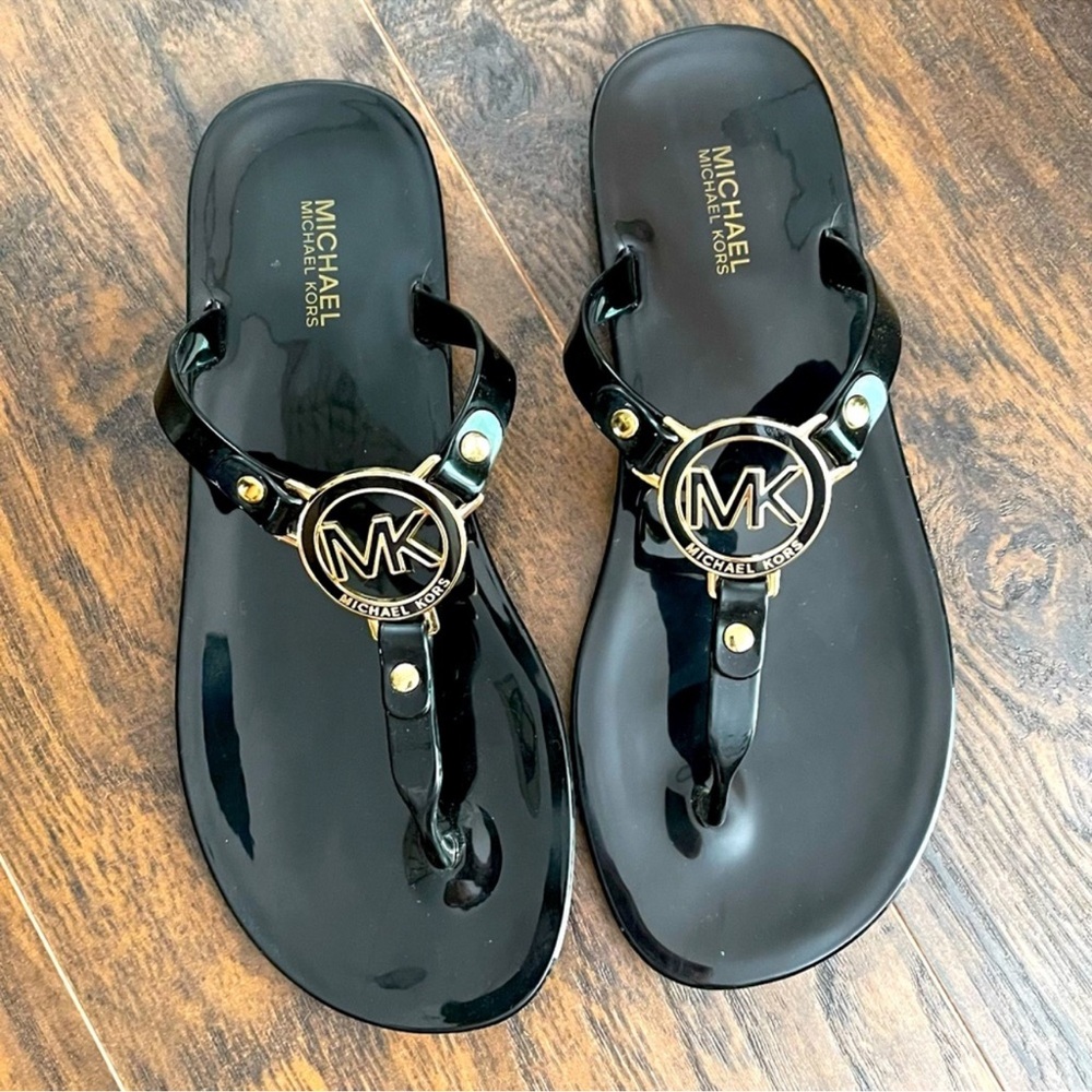 Michael Kors black sandals with gold accents.